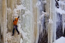 Homme grimpant la glace jaunie raide près de Saint Raymond, Québec, Canada — Photo de stock