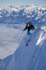 Man in mountains of Kicking Horse Resort before dropping into steep couloir, Golden, British Columbia, Canada — Stock Photo