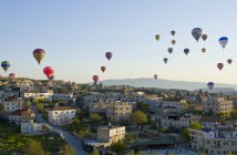 Hot air ballooning over town houses in Goreme, Cappadocia, Turkey — Stock Photo