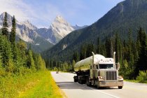 Transporte de camiones de propano a lo largo de la autopista Trans Canada en el Parque Nacional Glaciar, Canadá . - foto de stock