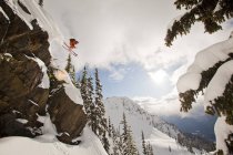 Male freeskier dropping cliff in backcountry at Revelstoke mountain resort, Canada — Stock Photo