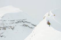 Два лыжника поднимаются на хребет в ледопаде Канадских Скалистых гор к северу от Голден, Британская Колумбия — стоковое фото