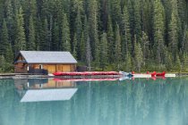 Réflexion des hangars à bateaux et des canots dans l'eau du lac Louise, parc national Banff, Alberta, Canada — Photo de stock
