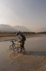 Mountain biker touring in Big Creek, South Chilcotin Mountains, Columbia Británica, Canadá - foto de stock