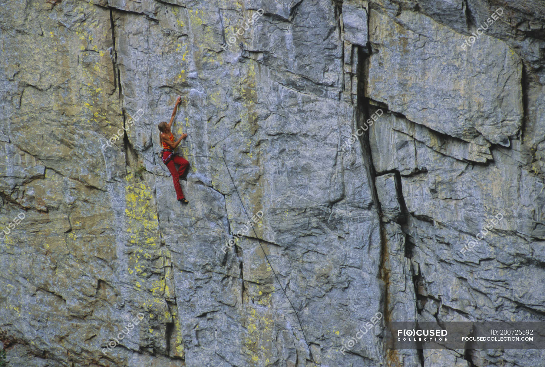 Female rock climber climbing rock on Tottering Pillar Wall, Grand
