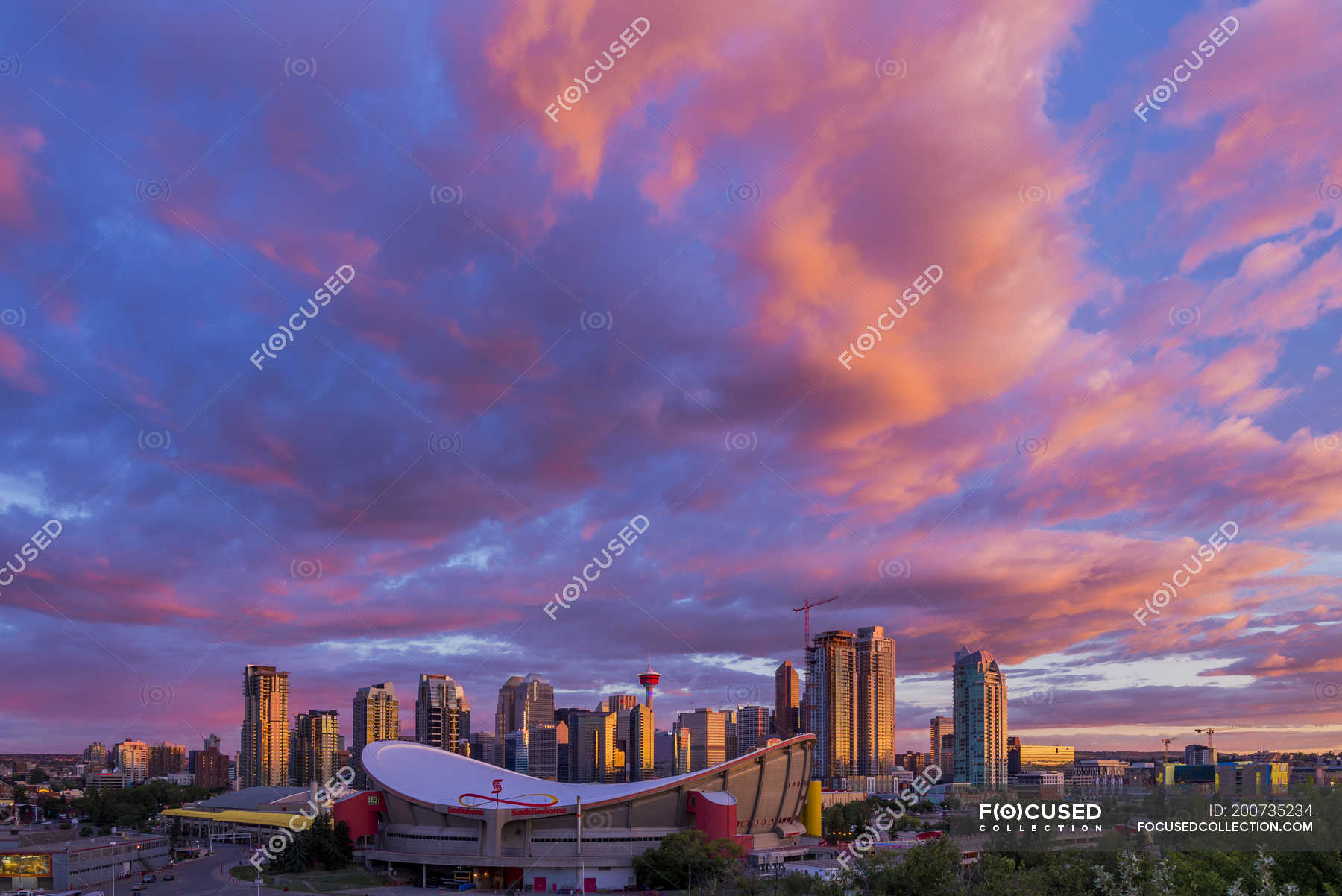 Saddledome arena and city skyline under dramatic sky, Calgary, Alberta