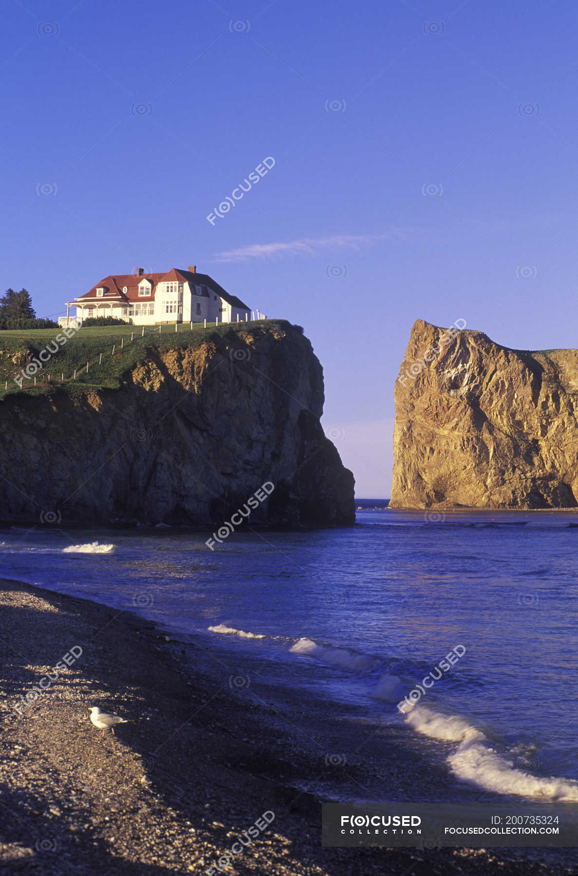 Perce Rock with house in village Perce on Gaspe Peninsula, Quebec ...