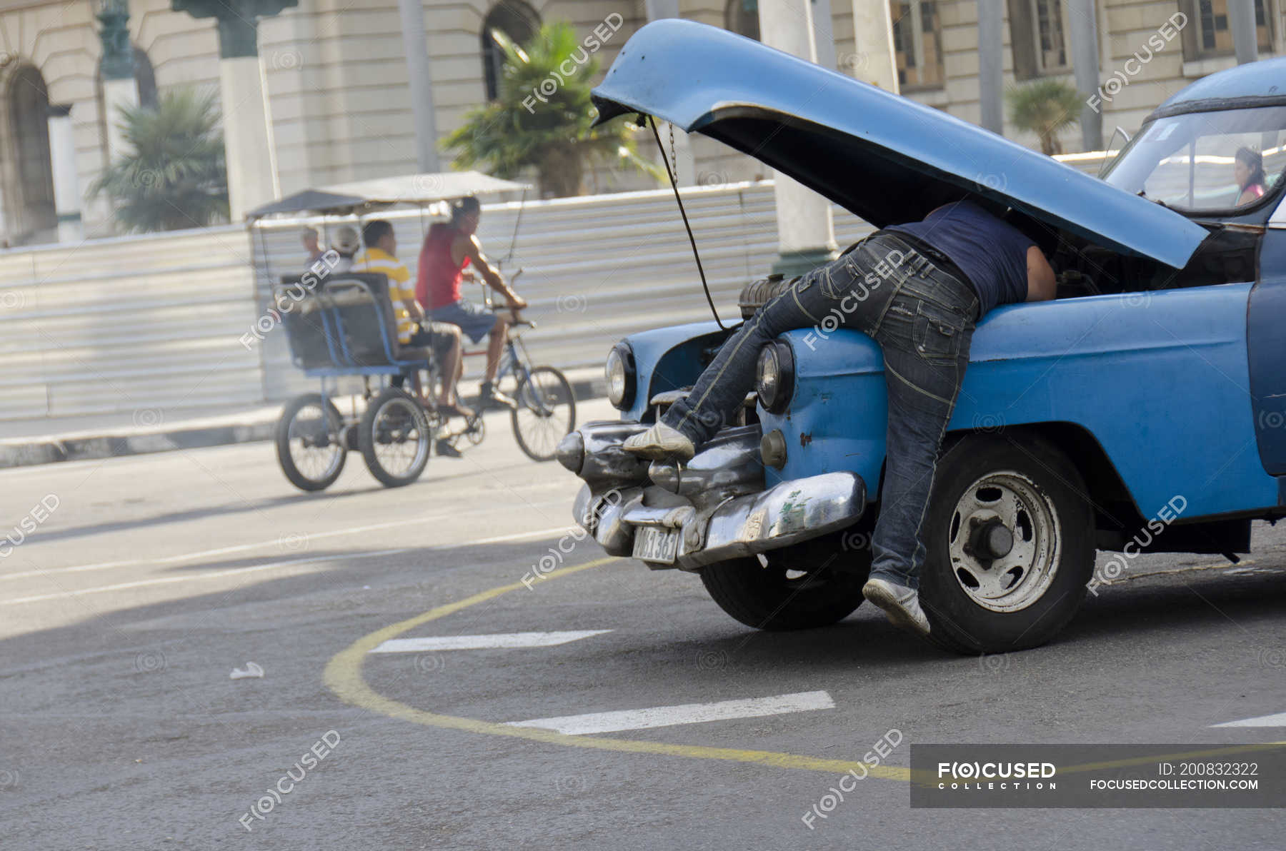 Man working on old car on street of Havana, Cuba — velotaxi, Men ...