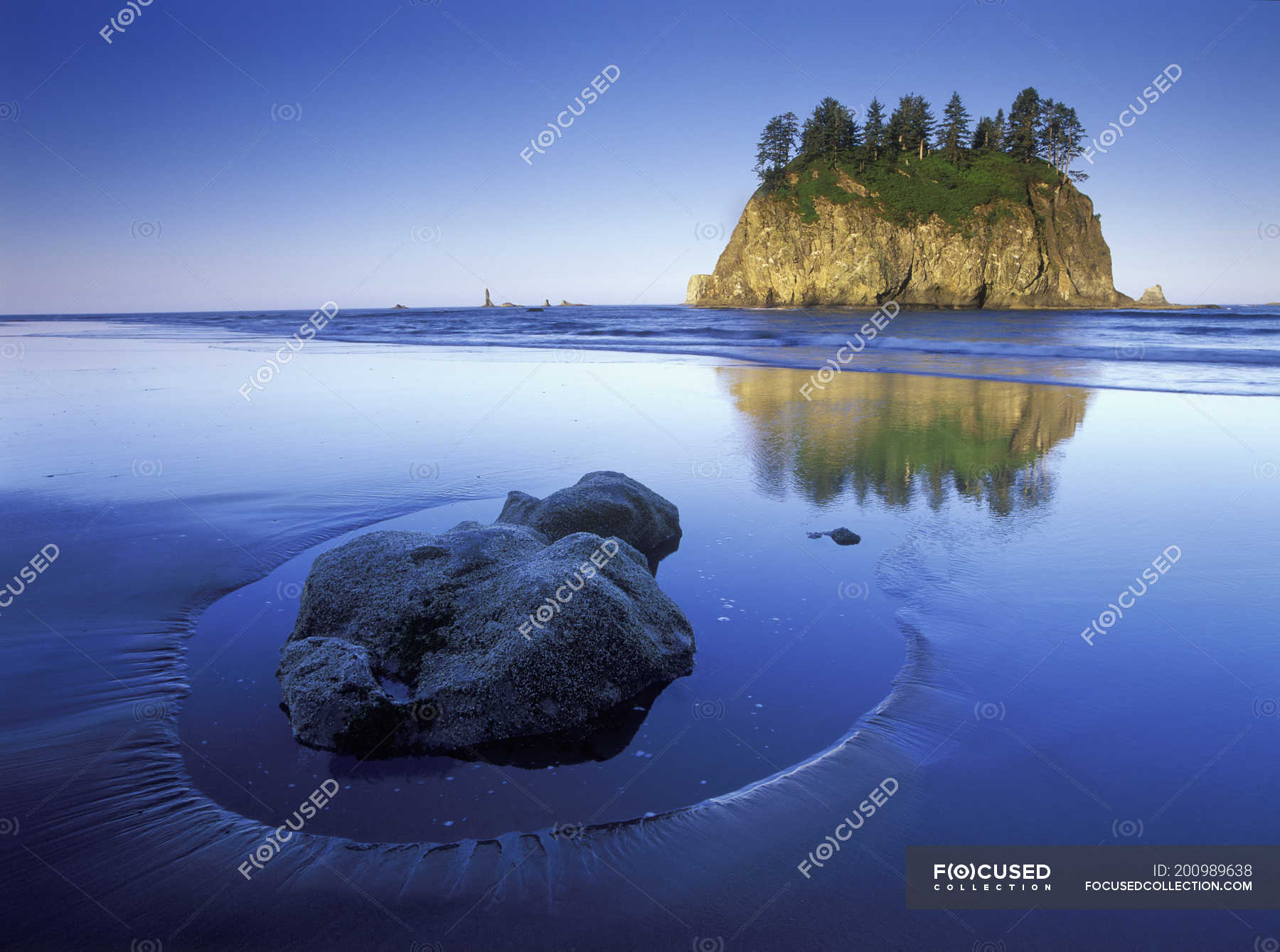 Rock in sand on Shi Shi Beach with sea stack island, Olympic National ...