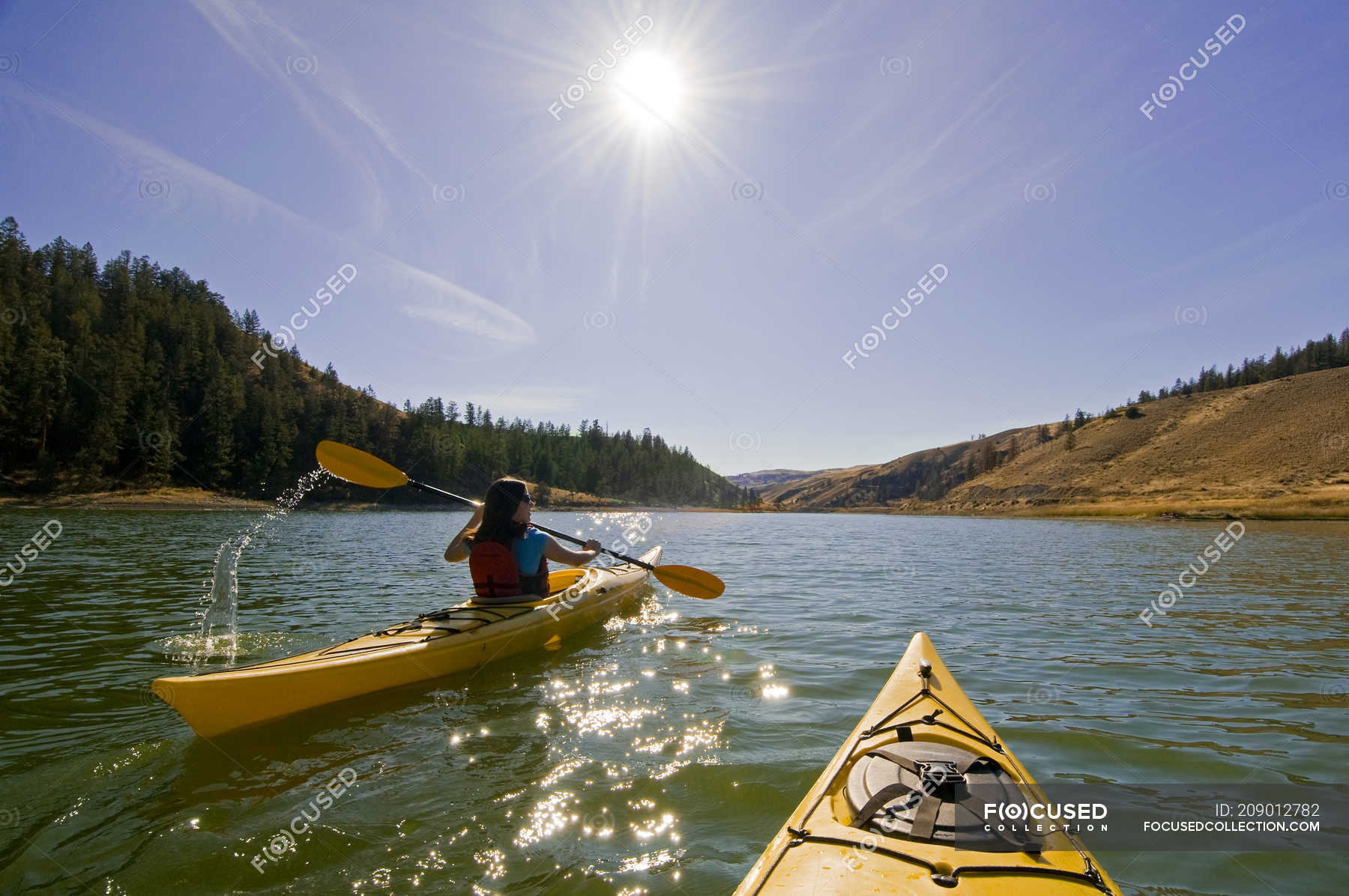 Rear view of woman kayaking in sunlight at Trapp Lake near Kamloops