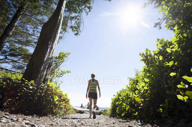 Veduta posteriore della giovane donna che cammina lungo il sentiero a China Beach nel Parco Naturale Juan de Fuca, Canada
. — Foto stock