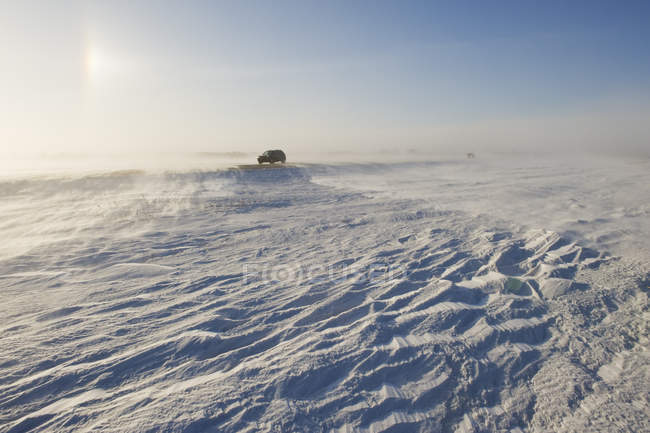 Car riding on road covered with blowing snow near Morris, Manitoba, Canada — Stock Photo
