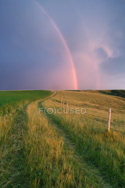 Rucktrail und weideland mit regenbogen in der nähe leader, saskatchewan, canada. — Stockfoto