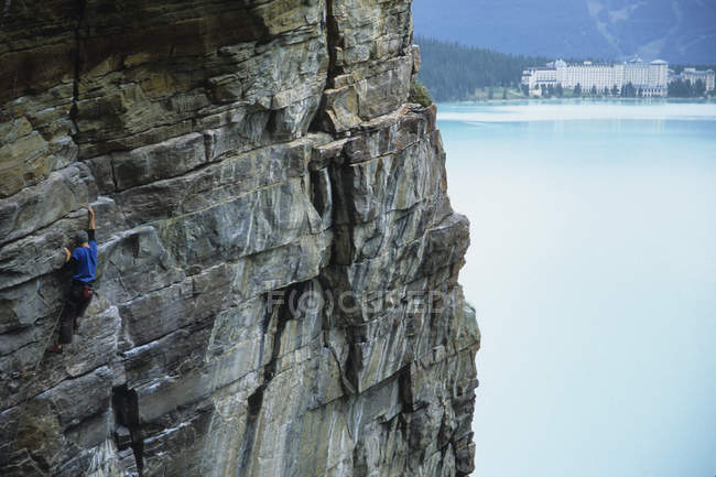 Escalador masculino que lidera la escalada en rocas, Lake Louise, Banff National Park, Alberta, Canadá - foto de stock