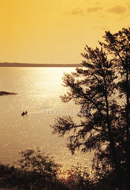 Silhuetas de pessoas que canoagem através de Big Whiteshell Lake, Whiteshell Provincial Park, Manitoba, Canadá — Fotografia de Stock