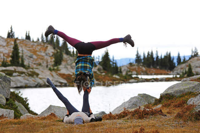 Dos amigos haciendo acro yog, Kokanee Glacier Park, Columbia Británica, Canadá - foto de stock