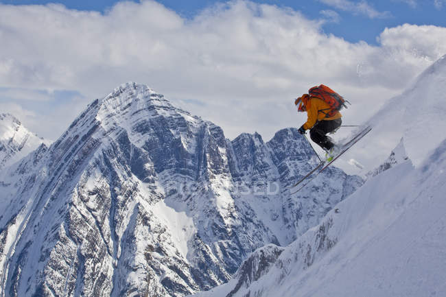 Hombre esquiador backcountry saltando en las montañas de Icefall Lodge, Golden, Columbia Británica, Canadá - foto de stock