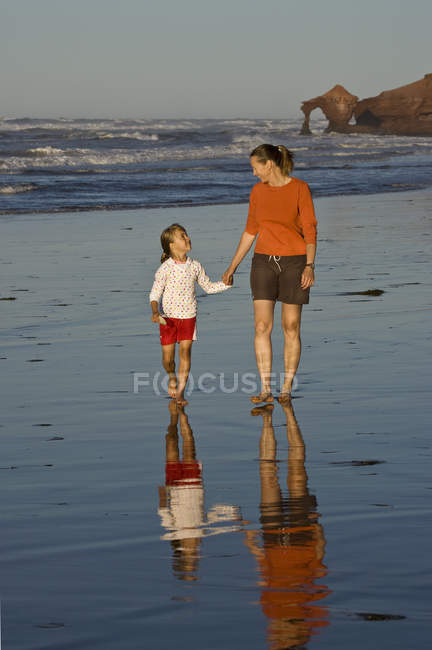 Жінка з дочкою ходьбі взявшись за руки на пляжі на Profitts точки поблизу Darnley, Острів Принца Едуарда, Канада. — стокове фото
