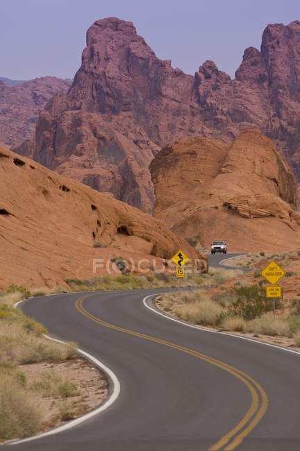 Carro andando na estrada através do Valley of Fire State Park, Nevada, EUA — Fotografia de Stock