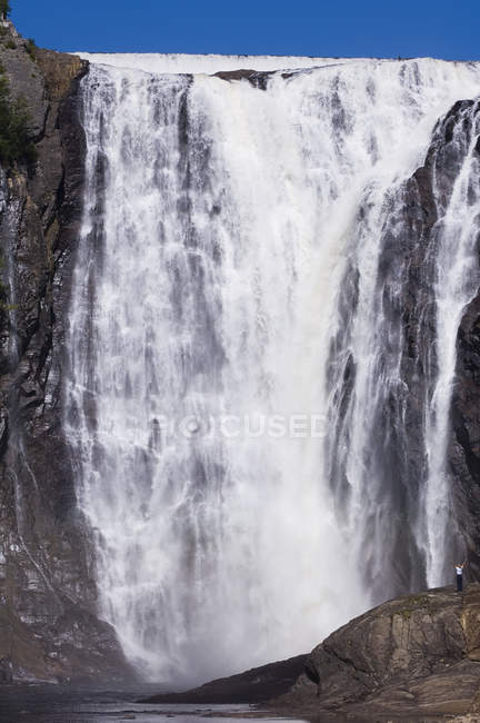 Woman with outstretched arms at Montmorency Falls, Quebec City, Quebec, Canada. — Stock Photo