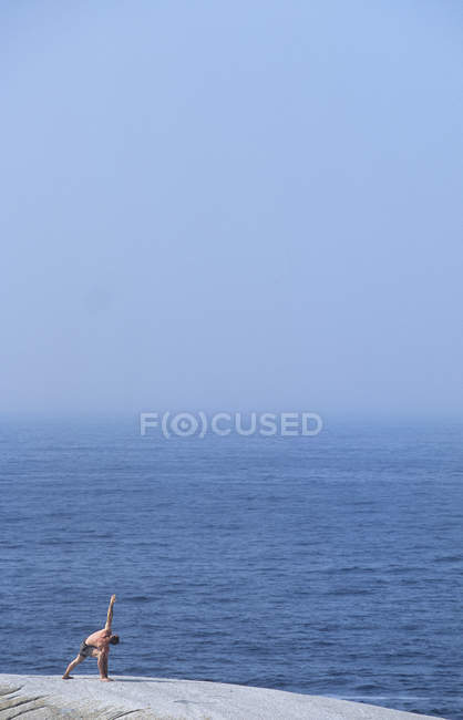 Mann macht Yoga an der Küste der Taubeninsel, Nova Scotia, Kanada. — Stockfoto