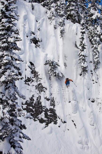 Male freeskier dropping cliff at Revelstoke Mountain Resort, Canada — Stock Photo
