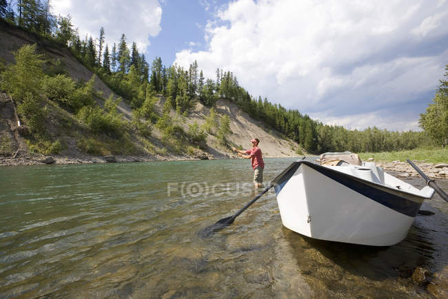 Hombre pesca con mosca en el río Elk desde dory, Fernie, East Kootenays, Columbia Británica, Canadá . - foto de stock
