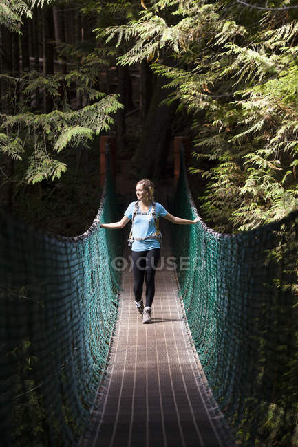 Молодая женщина-туристка на подвесном мосту между Чайна-Бич и Мистик-Бич вдоль Хуан-де-Фука Трейл, остров Ванкувер, Канада . — стоковое фото