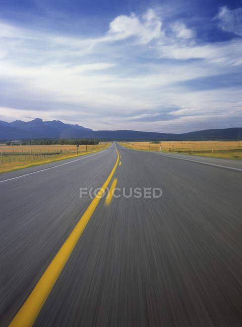 Auto-estrada através do campo no oeste de Cochrane, Alberta, Canadá . — Fotografia de Stock