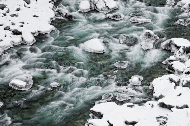 Fließendes Wasser des Baches in schneebedeckter Schlucht — Stockfoto
