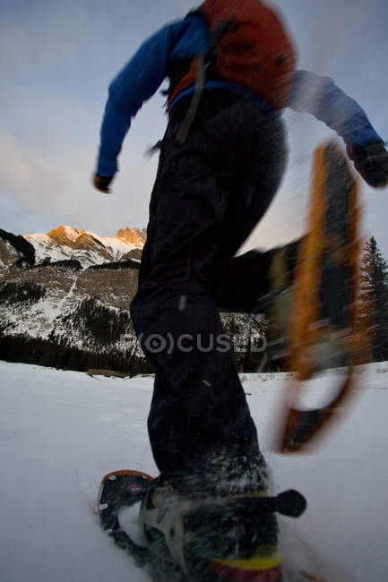 Vue en angle bas de la raquette profitant de la course tôt le matin au lac Minnewanka, parc national Banff, Alberta, Canada — Photo de stock