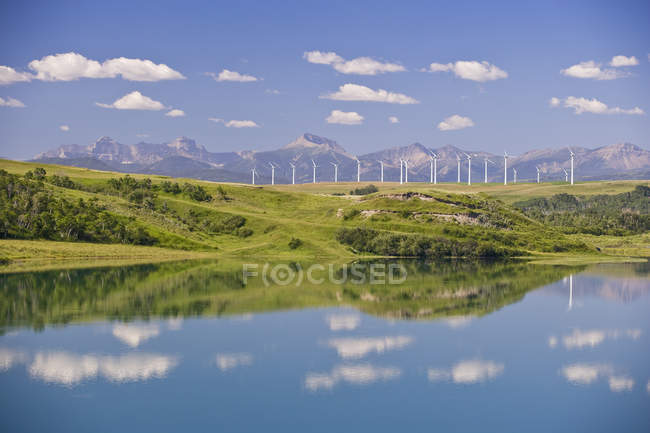 Molinos de viento generadores de energía y lago cerca de Pincher Creek, Alberta, Canadá . - foto de stock