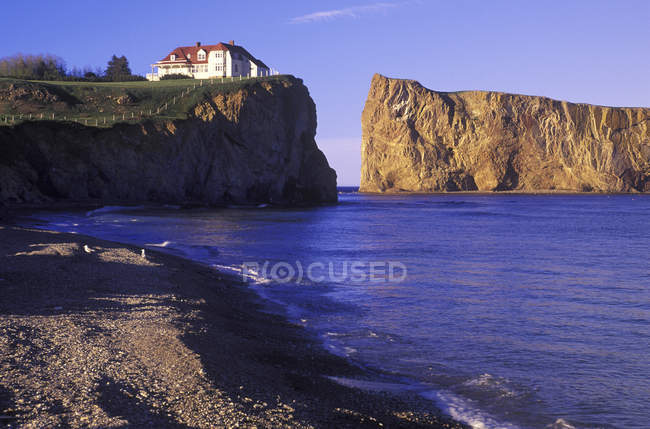 Perce Rock with house in village Perce on Gaspe Peninsula, Quebec, Canada. — Stock Photo