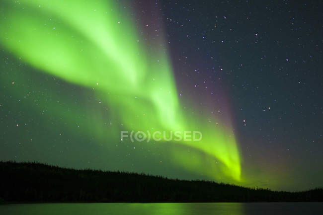 Aurores boréales éthérées au-dessus d'un lac en forêt boréale, environs de Yellowknife, Territoires du Nord-Ouest, Canada — Photo de stock