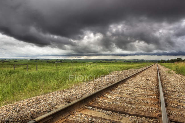 Caminhos de ferro com nuvens de tempestade no país perto de Didsbury, Alberta, Canadá — Fotografia de Stock