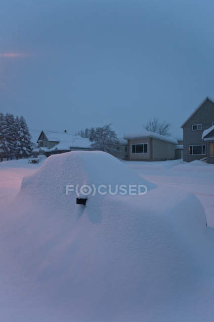 Street and vehicle covered in snow in twilight in ski town Revelstoke, Canada — Stock Photo