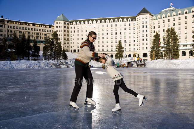 Pattinaggio su ghiaccio madre e figlia davanti all'hotel Lake Louise, Banff National Park, Alberta, Canada . — Foto stock