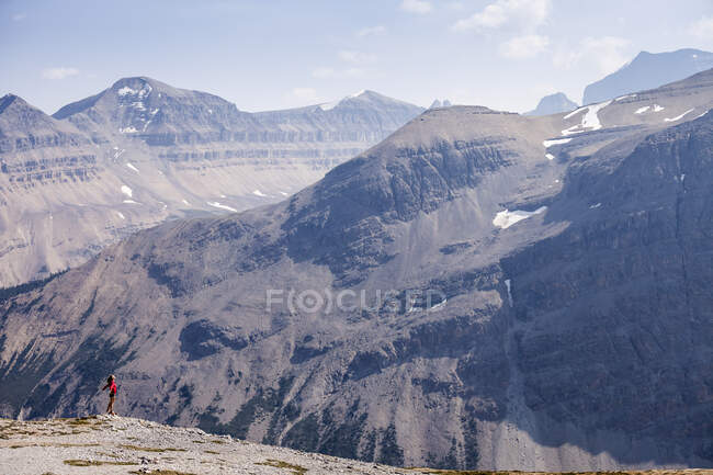 Una mujer joven se levanta sobre Parker Ridge, Banff National Park, Alberta, Canadá - foto de stock