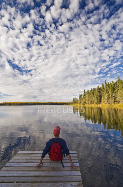 Man sitting on dock, Hanging Heart Lakes, Prince Albert National Park, Saskatchewan, Canadá — Fotografia de Stock