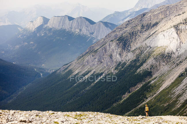 A young woman hikes the Sulphur Skyline Trail with a view of Ashlar Ridge. Miette Hotsprings, Jasper National Park, Alberta, Canada. — Stock Photo