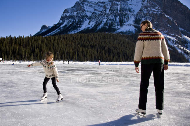 Mutter und Tochter Schlittschuhlaufen auf der Eisbahn am Lake Louise, Banff National Park, Alberta, Kanada. — Stockfoto