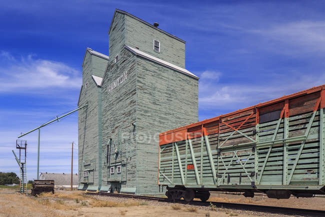Elevadores de granos y viejo vagón de ganado, Nanton, Alberta, Canadá - foto de stock