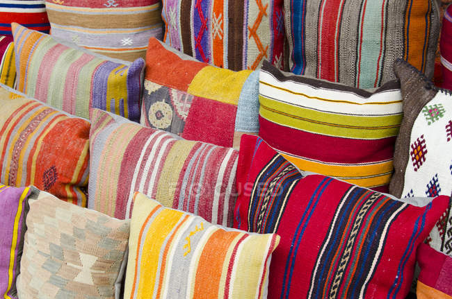 Almohadas de mercancías de colores en la tienda de regalos, marco completo - foto de stock