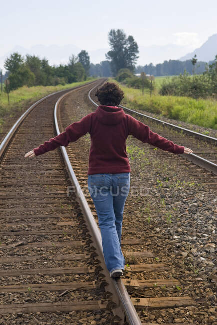 Une femme équilibre sur les voies ferrées de la vallée du Fraser, Colombie-Britannique, Canada. — Photo de stock