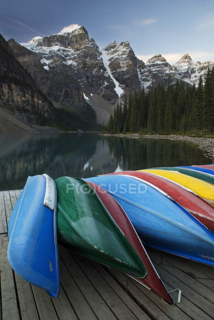 Barcos de canoa atracados no Lago Moraine nas montanhas do Parque Nacional Banff, Alberta, Canadá — Fotografia de Stock
