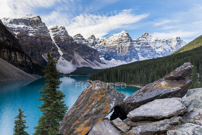 Orilla rocosa y agua turquesa del lago Moraine en las montañas del Parque Nacional Banff, Canadá . - foto de stock