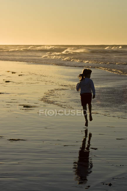 Pre-adolescent girl running along beach at Profitts Point near Darnley, Prince Edward Island, Canada. — Stock Photo