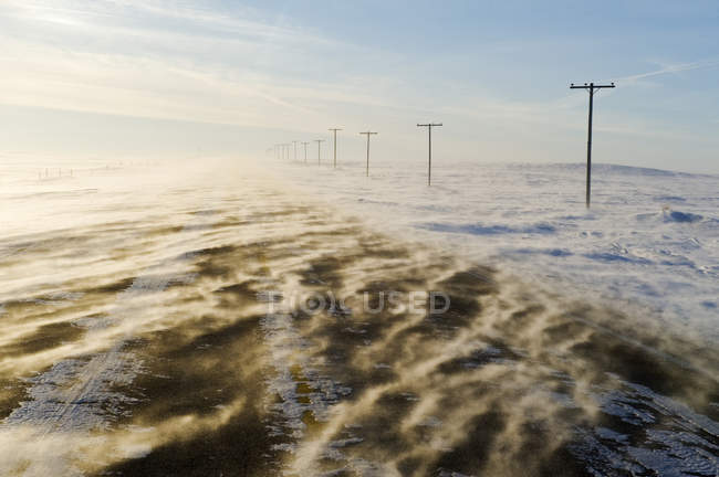 Estrada coberta com neve soprando perto de Verwood, Saskatchewan, Canadá — Fotografia de Stock