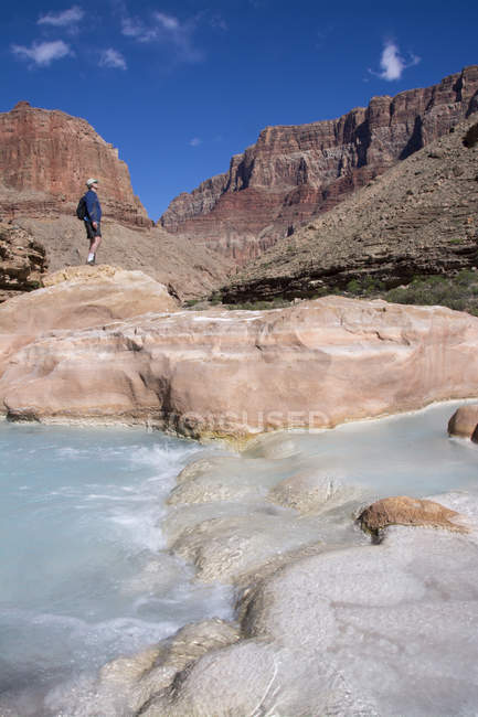 Randonneur à Little Colorado River coloré par le carbonate de calcium et le sulfate de cuivre à Grand Canyon, Arizona, États-Unis — Photo de stock