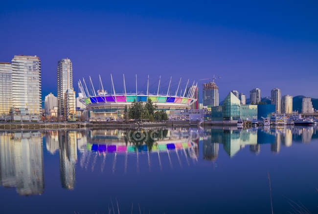 Stade illuminé réfléchissant dans l'eau de False Creek, Vancouver, Colombie-Britannique, Canada
, — Photo de stock
